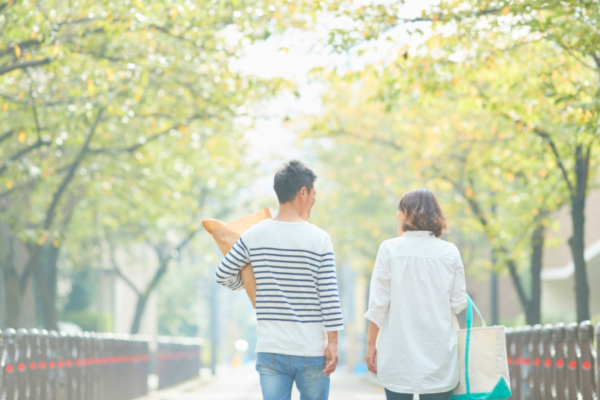 朝の並木道を歩く男女の後ろ姿 健康習慣カテゴリのイメージ写真