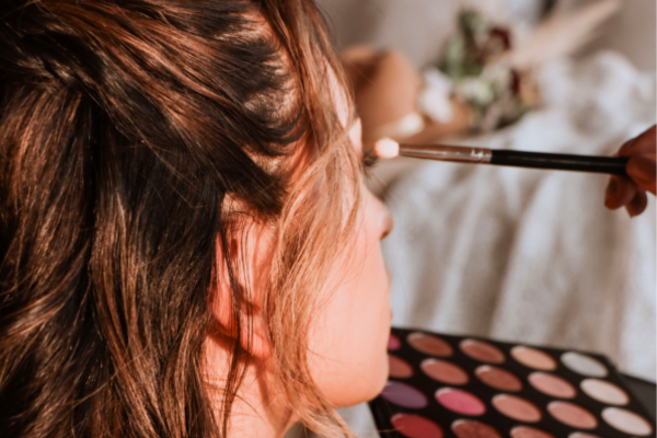 alt="女性がメイクブラシでアイメイクをしている女性美容カテゴリの写真
